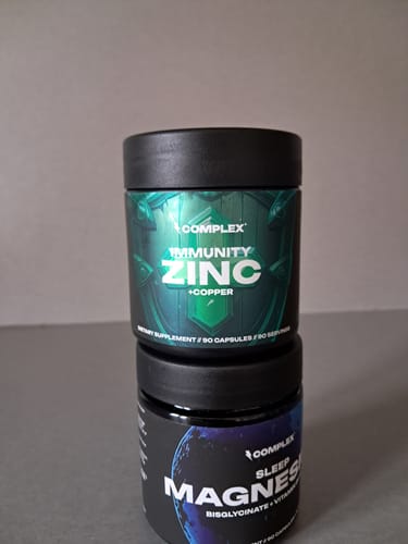 Reviewer's photo of the black jar of Immunity Zinc with a green label, stacked on another supplement.