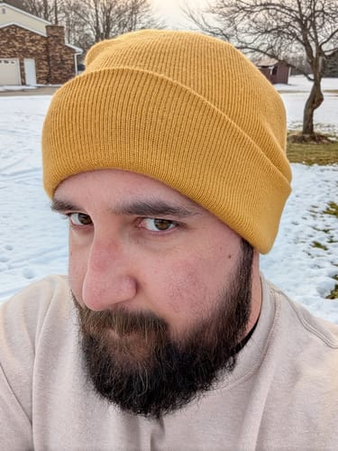 Reviewer in a close-up photo wearing a mustard yellow Big Beanie.