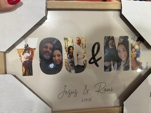 Reviewer's personalized "You & Me" poster showing photos of a couple within the letters, displayed in a light-colored frame.