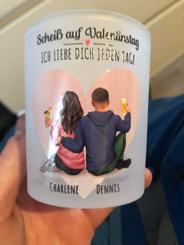 Ein Kunde hält den personalisierten Teelichthalter aus satiniertem Glas, der mit einem Paar und den Namen Charlene und Dennis bedruckt ist.