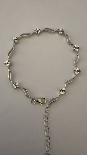 Reviewer's Silver Flamboyant Bracelet laid out, showing the wavy band design and faceted details.