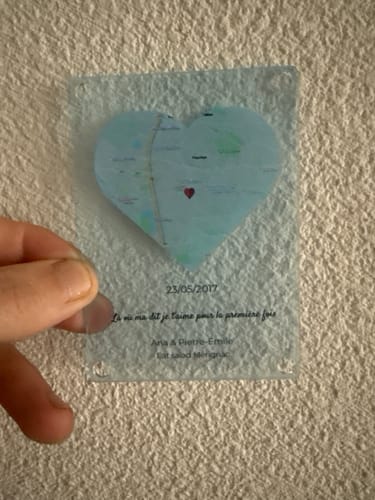 Ein Kunde hält den transparenten „Notre événement“-Magneten mit einer herzförmigen Karte und persönlichem Text.