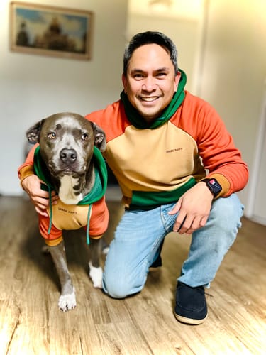 Reviewer and their dog pose together in their matching color-block Ranger Human Hoodies.