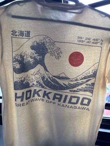 Customer's close-up of the Hokkaido Wave T-Shirt in cream, showing the 'Great Wave off Kanagawa' graphic on the back.