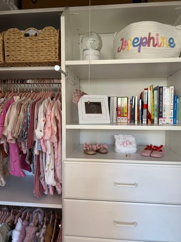 Customer's personalized knitted basket with 'Josephine' in multicolor yarn, displayed on a white closet shelf.