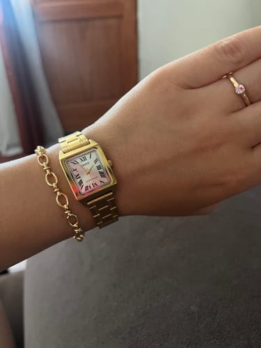 Cliente luciendo el delicado reloj Casio Tank dorado en la muñeca junto con una pulsera.