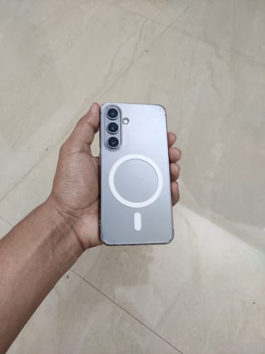 Reviewer holding a silver Galaxy S24, showcasing the sleek, clear Magsafe case.