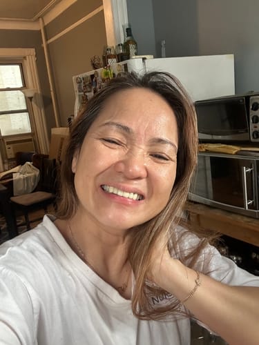 Reviewer smiling happily, showing their glowing face after using F-Balm.