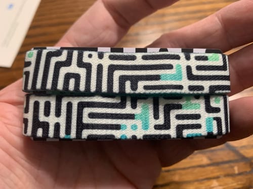 Customer holding two stacked Never Lose Hope Bracelets, showing the outer black and white maze pattern.