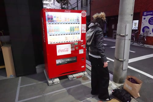 Reviewer wearing wide-leg black Raw Denim Jeans on a city street at night.