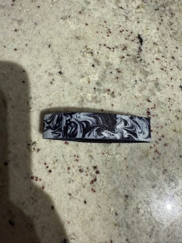Customer's Keep Going Interactive Bracelet with a black and white marble pattern, shown on a countertop.