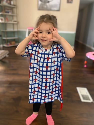 Customer wearing the All American Plaid Fringe T-Shirt Dress, showing the plaid pattern and red side fringe.