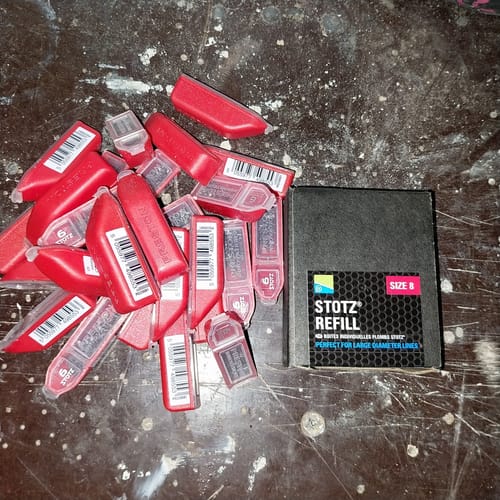 Recensent toont een stapel STOTZ REFILLS in rode verpakkingen naast de doos.