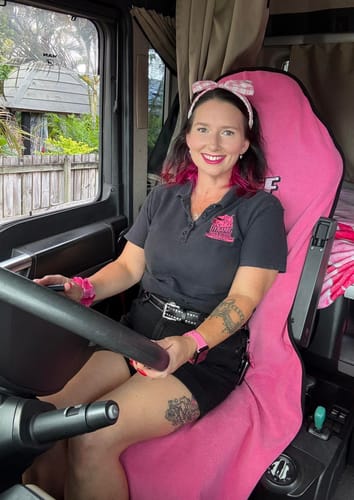Reviewer showing the pink Waterproof Car Towel Seat Cover on the driver's seat of their truck.