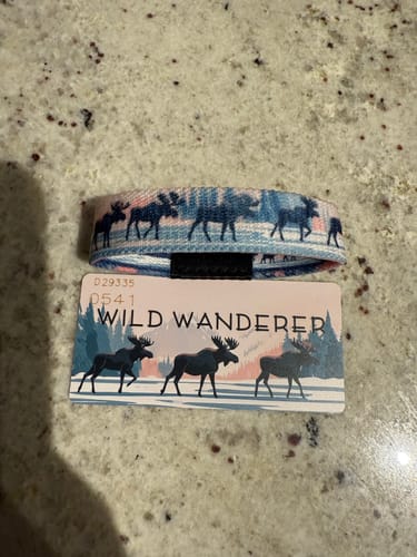 Customer's Wild Wanderer Bracelet with a moose pattern, shown with its matching packaging card on a countertop.