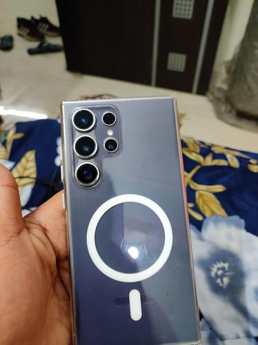 Customer holding the Anti Yellow Magsafe Clear Case on a dark phone, showing the back and MagSafe ring.