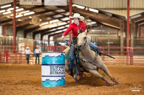 Reviewer's horse making a sharp turn around a barrel during a rodeo competition.