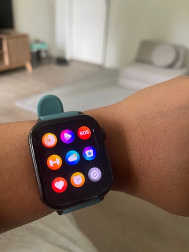 Customer wearing the Gard Pro Health Smartwatch 3 with a teal band, displaying a grid of colorful app icons.