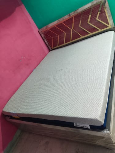 Customer's Flo Anti-Gravity mattress, still partially wrapped, on a bed frame showing its textured white top.