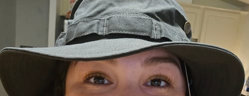Close-up of a reviewer wearing the grey Big Boonie Bucket Hat, showing the brim just above their eyes.
