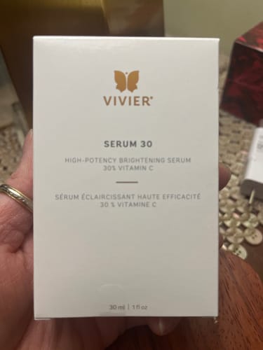 A customer's hand holding the white box of Vivier Serum 30.