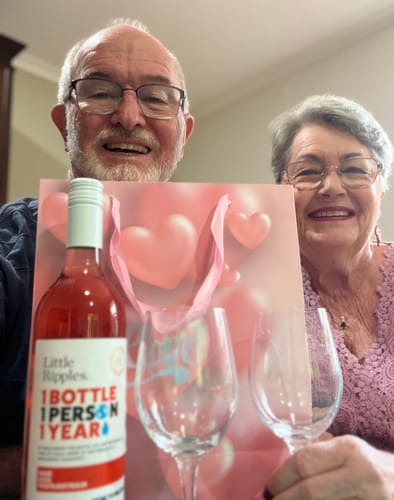 Reviewers celebrating with a bottle of Little Ripples Rosé, two glasses, and a Valentine's Day gift bag.