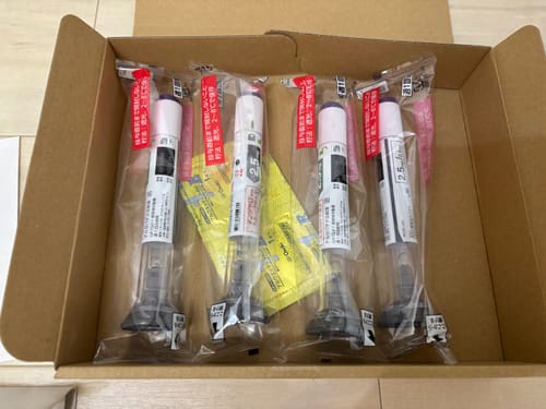 購入者が開封した段ボール箱の中に、個包装された4本のマンジャロ（2.5mg）が入っている様子。
