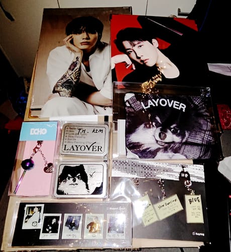 Customer's K-POP RANDOM BOX contents, showing posters, photocards, and keychains from the BTS album 'Layover'.