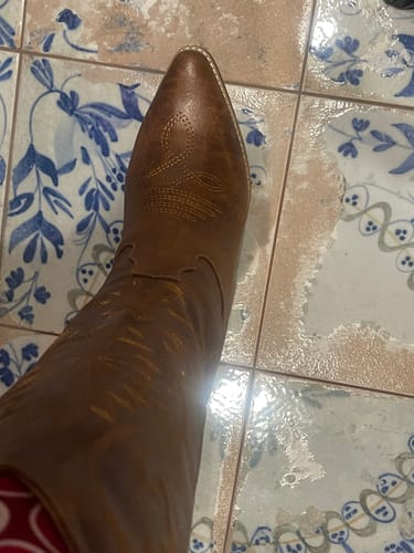 Customer showing a close-up of the brown Corky's Saddle Just In Case Boot, highlighting the western embroidery on the toe.