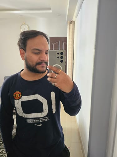 Reviewer takes a mirror selfie, showing the clear Magsafe case on their Samsung Galaxy S24 Ultra.