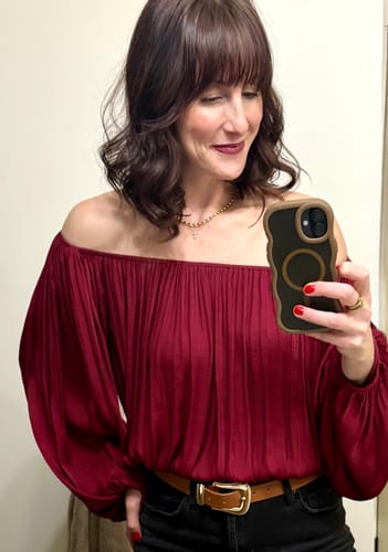 Reviewer taking a selfie wearing the gold Malaga Bead Necklace, layered with a longer cross necklace.