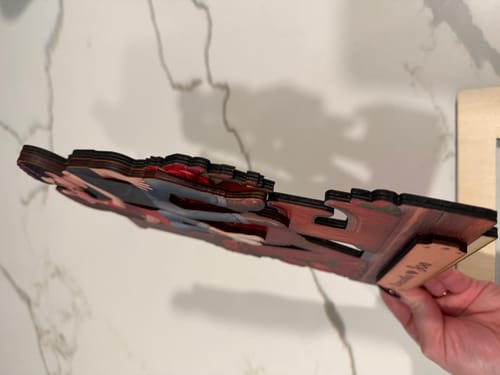 Close-up: A reviewer's hand holds the Eternal LOVE plaque, showing the layered wooden design from the side.