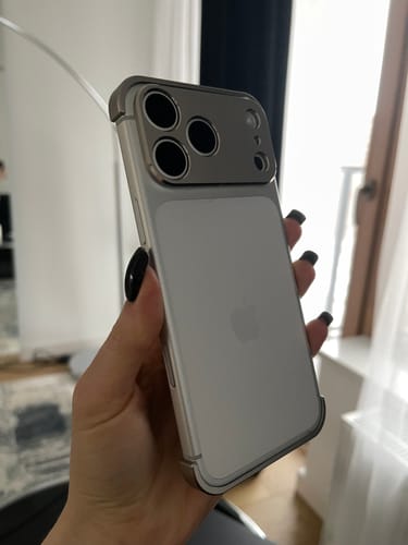 Customer holding a white iPhone showing the back view of the silver EdgeGuard Air Metal case.