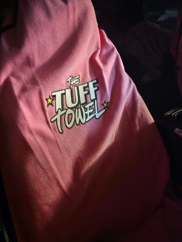 Close-up of a customer's pink Tuff Towel car seat cover, highlighting the brand logo.