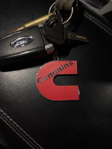 Customer's red Cummins keychain attached to a set of keys on a black surface.