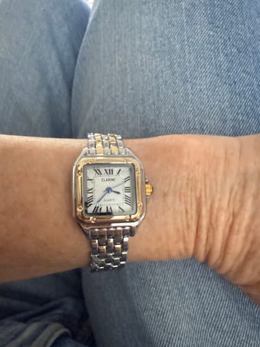 Customer wearing the Grealy De Mains watch on their wrist, showing its two-tone silver and gold band and square face.