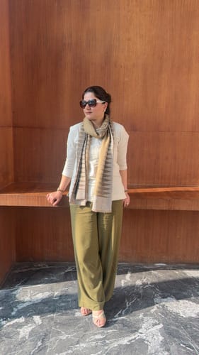 Reviewer standing outdoors wearing the Women Ecru Airy Linen Short Kurta, styled with green pants and a scarf.