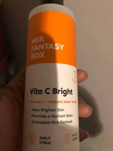Close-up of a customer holding the bottle of Vita C Bright Turmeric Body Wash.