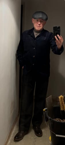 Reviewer wearing the gray Merino Wool Turtleneck Sweater layered under a dark jacket and cap.