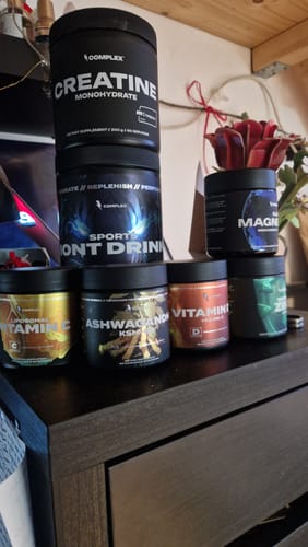Customer's Ashwagandha KSM-66 tub among a collection of other supplements on a dresser.