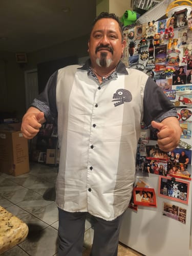 Reviewer wearing the Miquiztli Button Up Guayabera Shirt, showing its relaxed fit and color-blocked design in a kitchen.