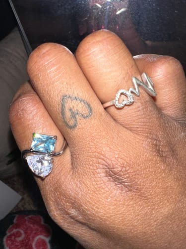 Close-up: Customer's hand wearing the Navae Birthstone Ring with two distinct stones.