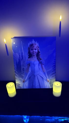 Customer's 'The Ice Princess' canvas portrait displayed on a shelf and lit by glowing candles.