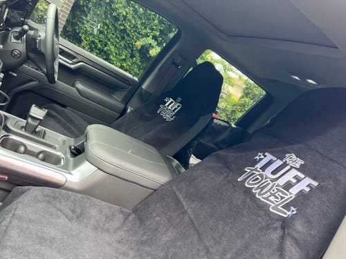 Reviewer's two black Waterproof Car Towel Seat Covers on the front seats of their vehicle.