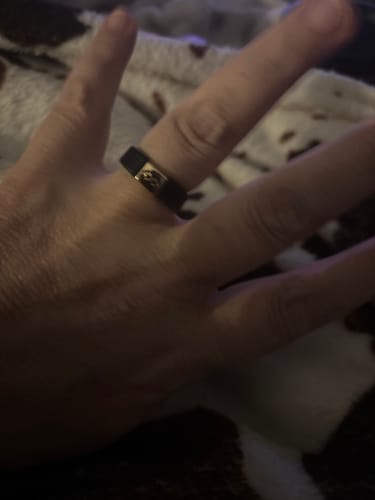 Customer showing the black MetalInfinity silicone ring with a gold metal detail on their finger.