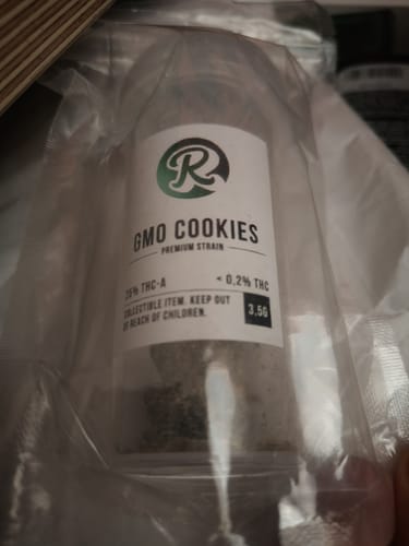 Customer's close-up of the GMO COOKIES jar in its original clear packaging, showing the product label.