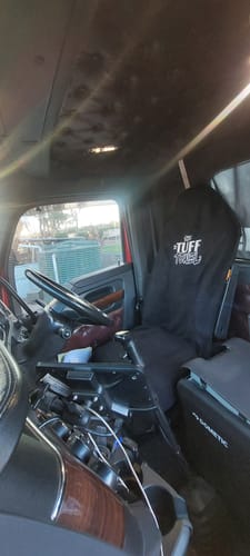 Customer's black Waterproof Car Towel Seat Cover on the driver's seat inside a truck cab.