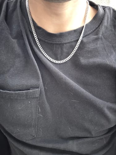 Cliente usando la Cadena Miami Cuban plateada de 5 mm sobre una camiseta negra.