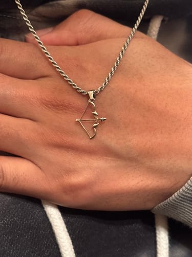 Customer showing the CUPID’S BOW PENDANT on a silver rope chain resting on their hand.