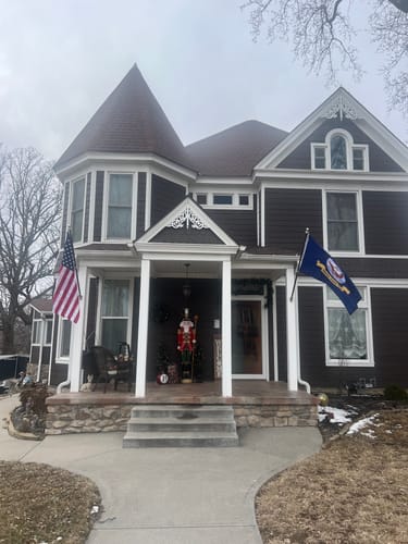 Reviewer's Prestige House Flag Pole with an American flag installed on the porch of a two-story home.